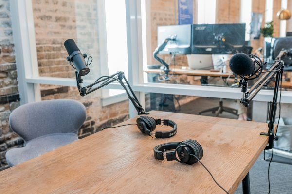 two black headphones on brown wooden table